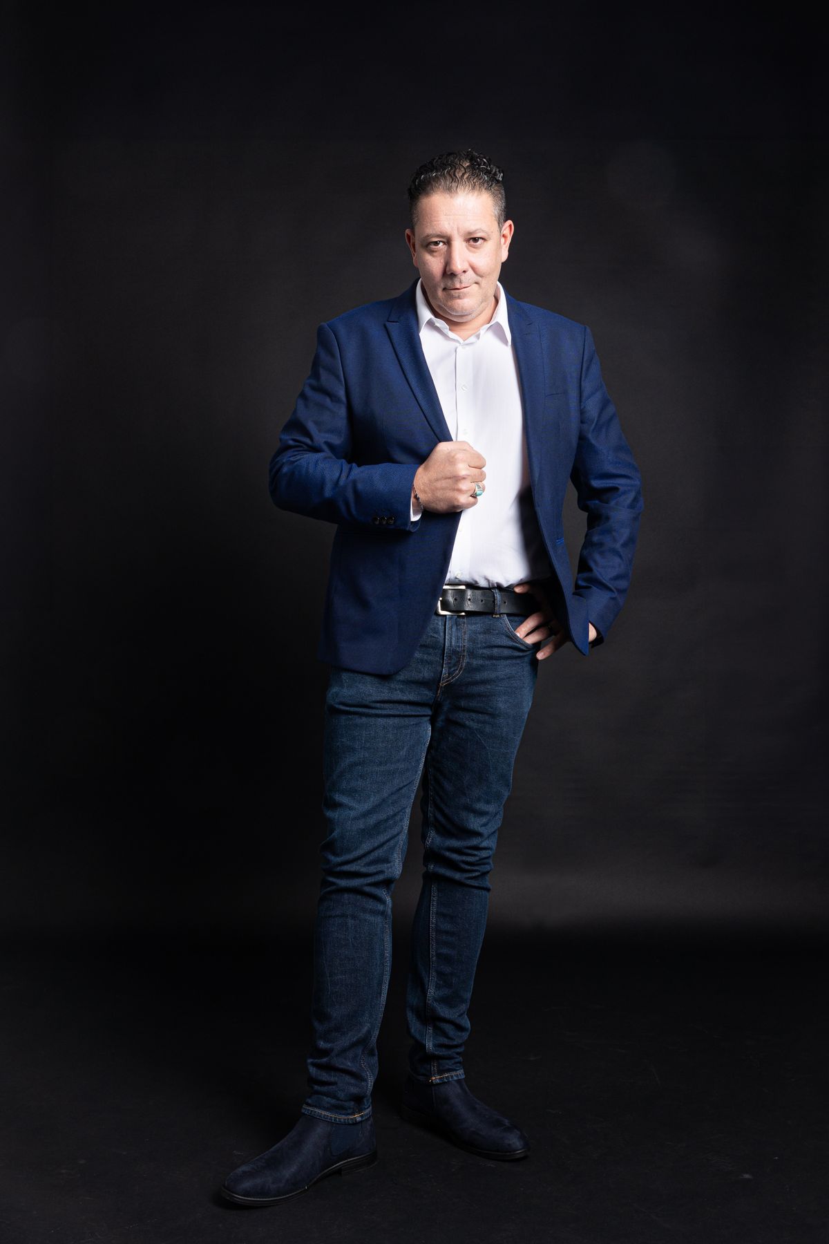 A navy blazer paired with a white shirt and blue jeans.
