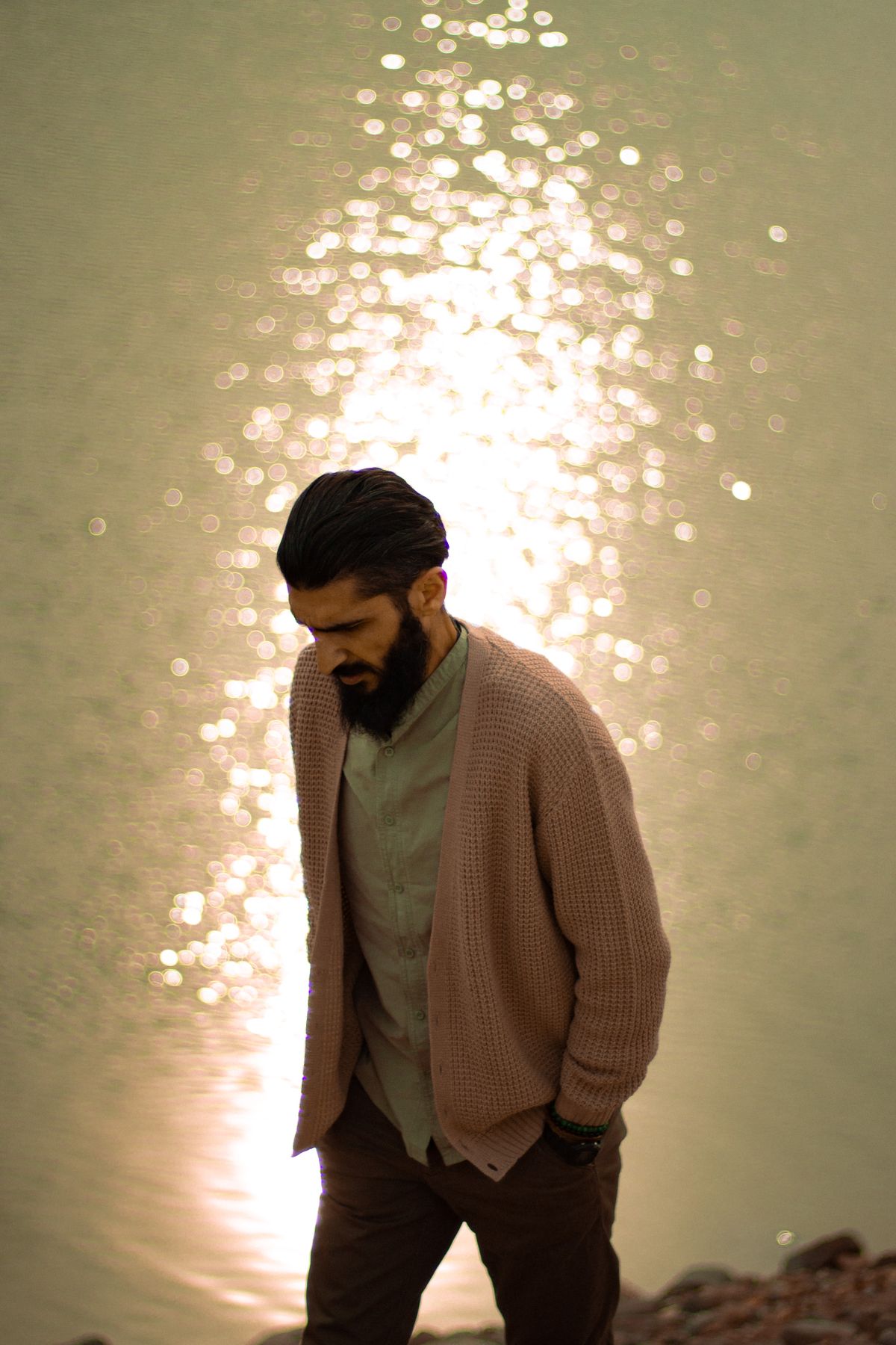 A brown cardigan layered over a light shirt by the water.
