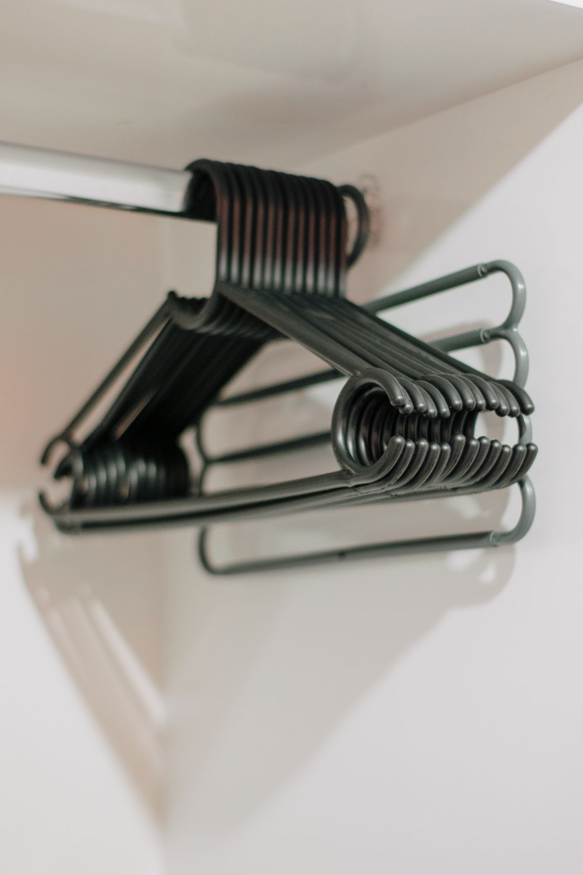 Several empty clothes hangers on a wardrobe rail.