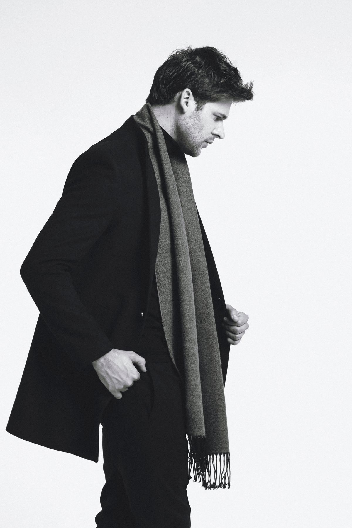 A long scarf draped over a dark tailored coat.