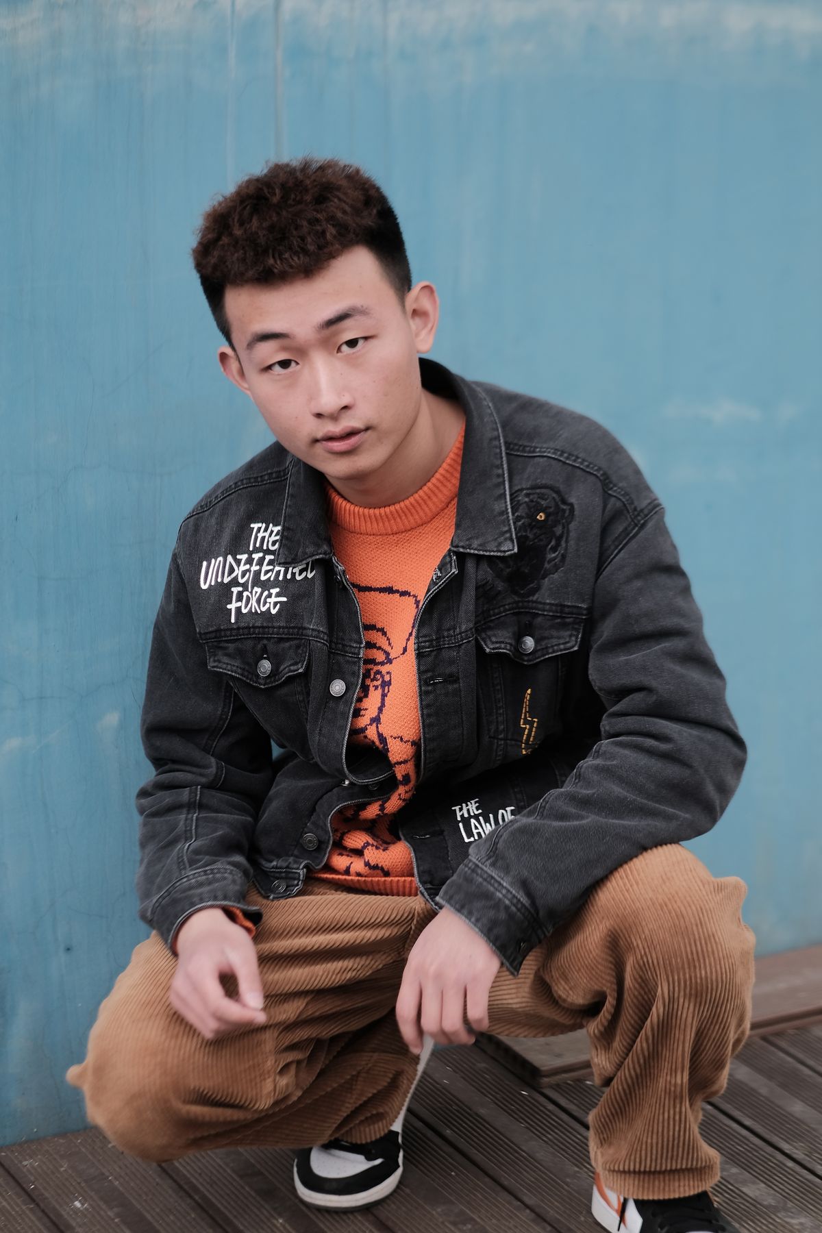 Brown corduroy trousers paired with a black denim jacket.