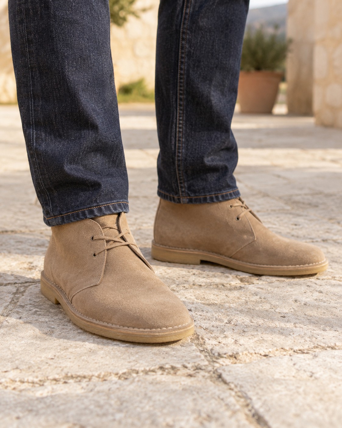 Sand-coloured suede desert boots worn with dark indigo jeans.