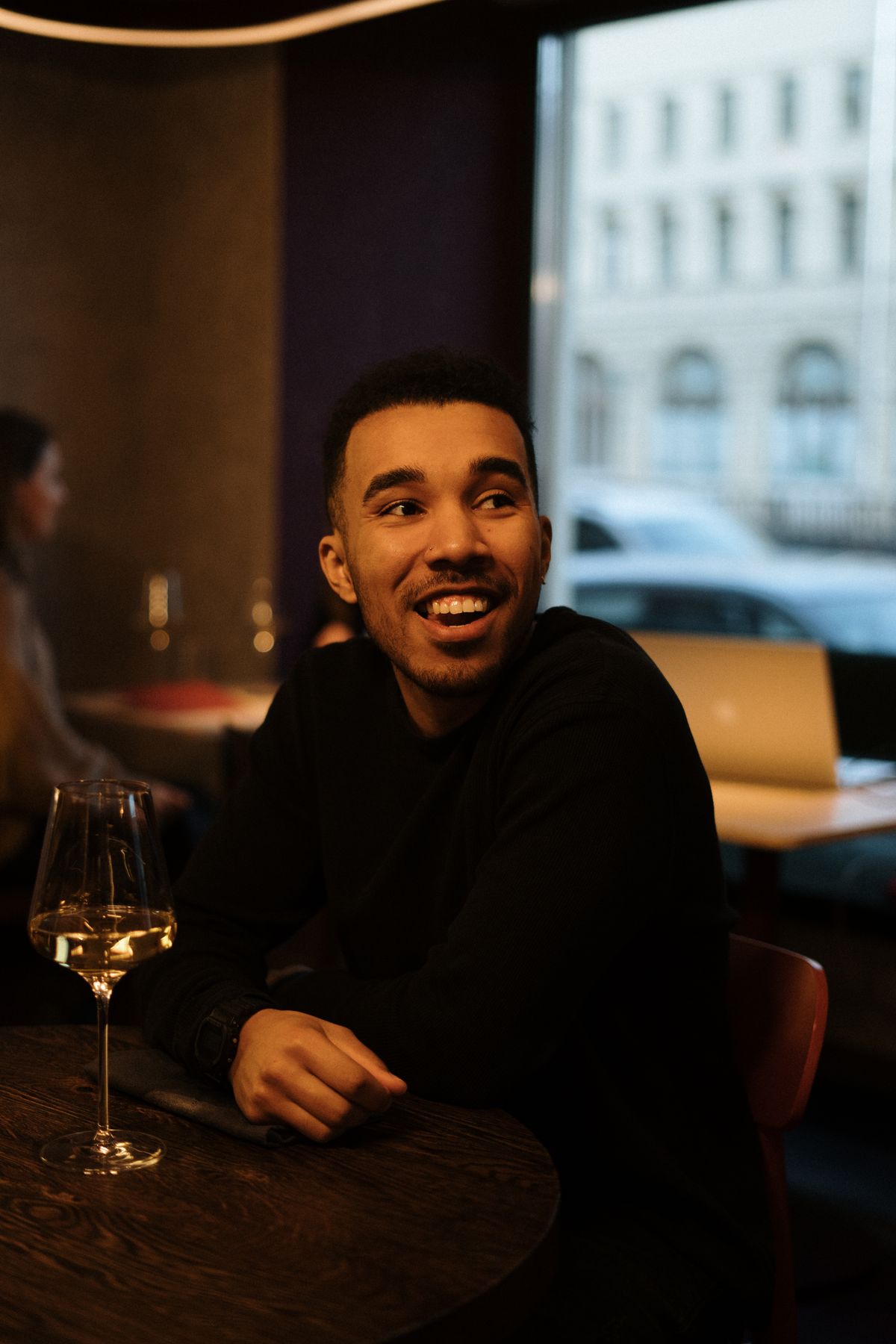A man wearing a dark shirt at a restaurant table.