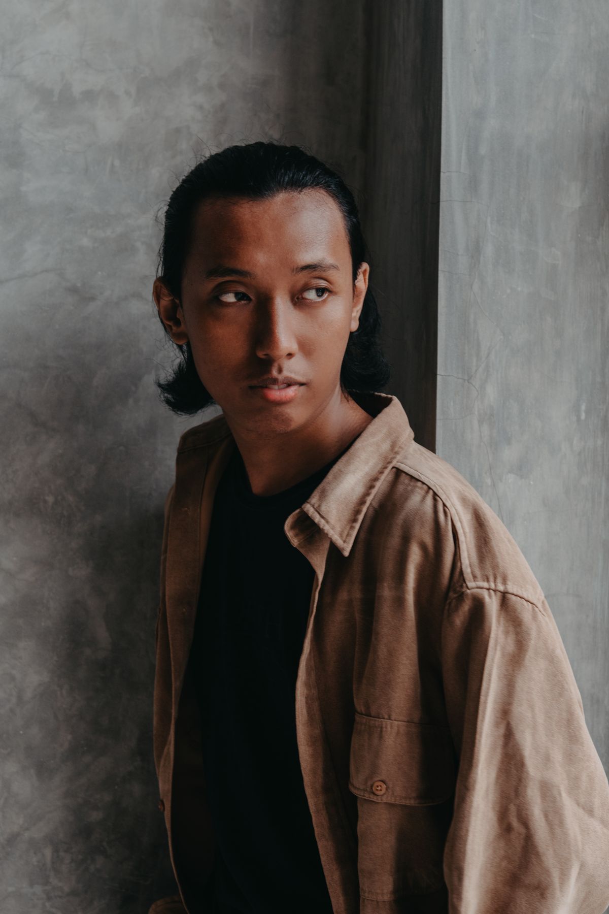 A brown overshirt worn open over a black top.