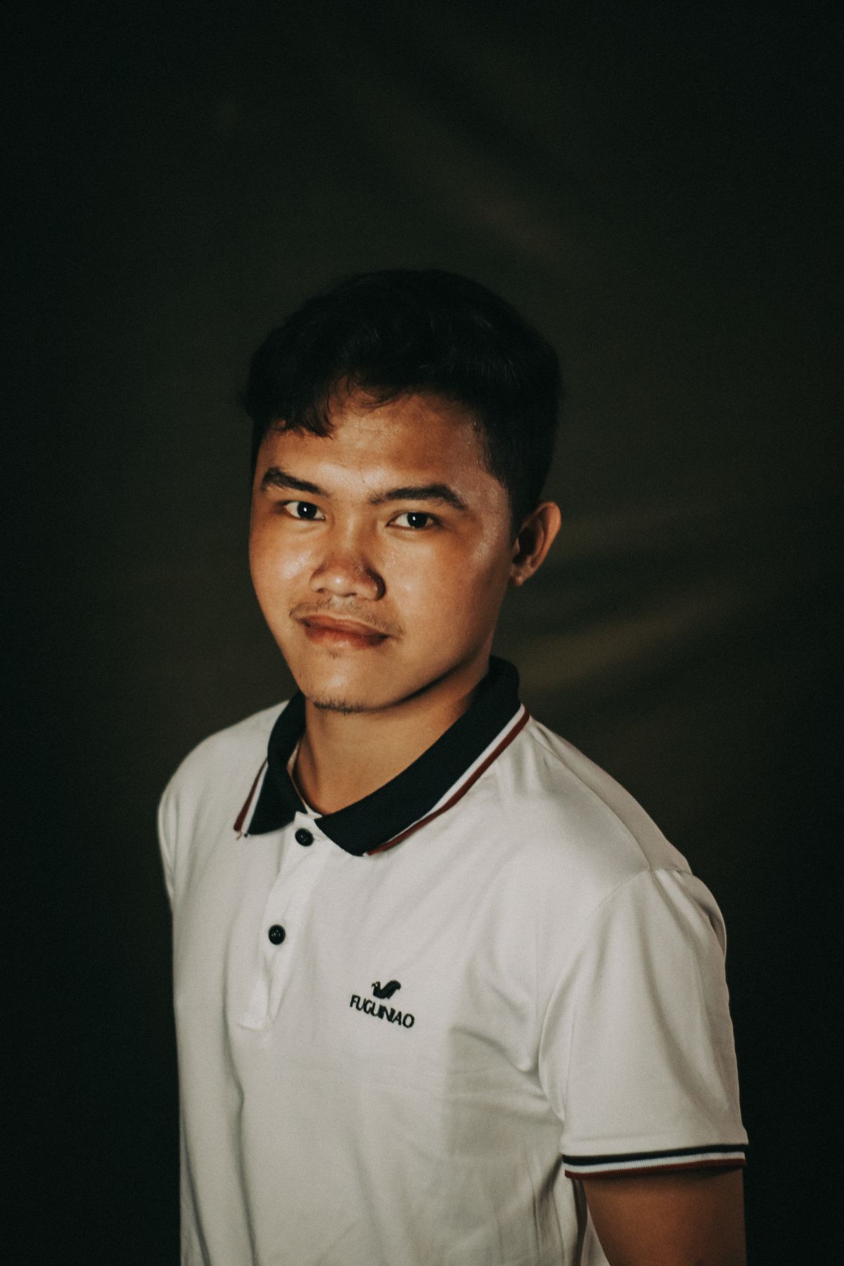 A white polo shirt with a dark contrast collar and button placket.