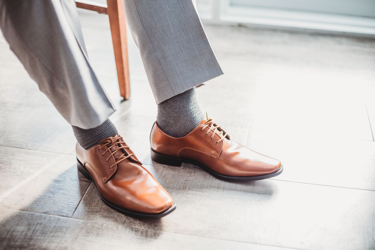 Grey socks connecting grey trousers and brown dress shoes.