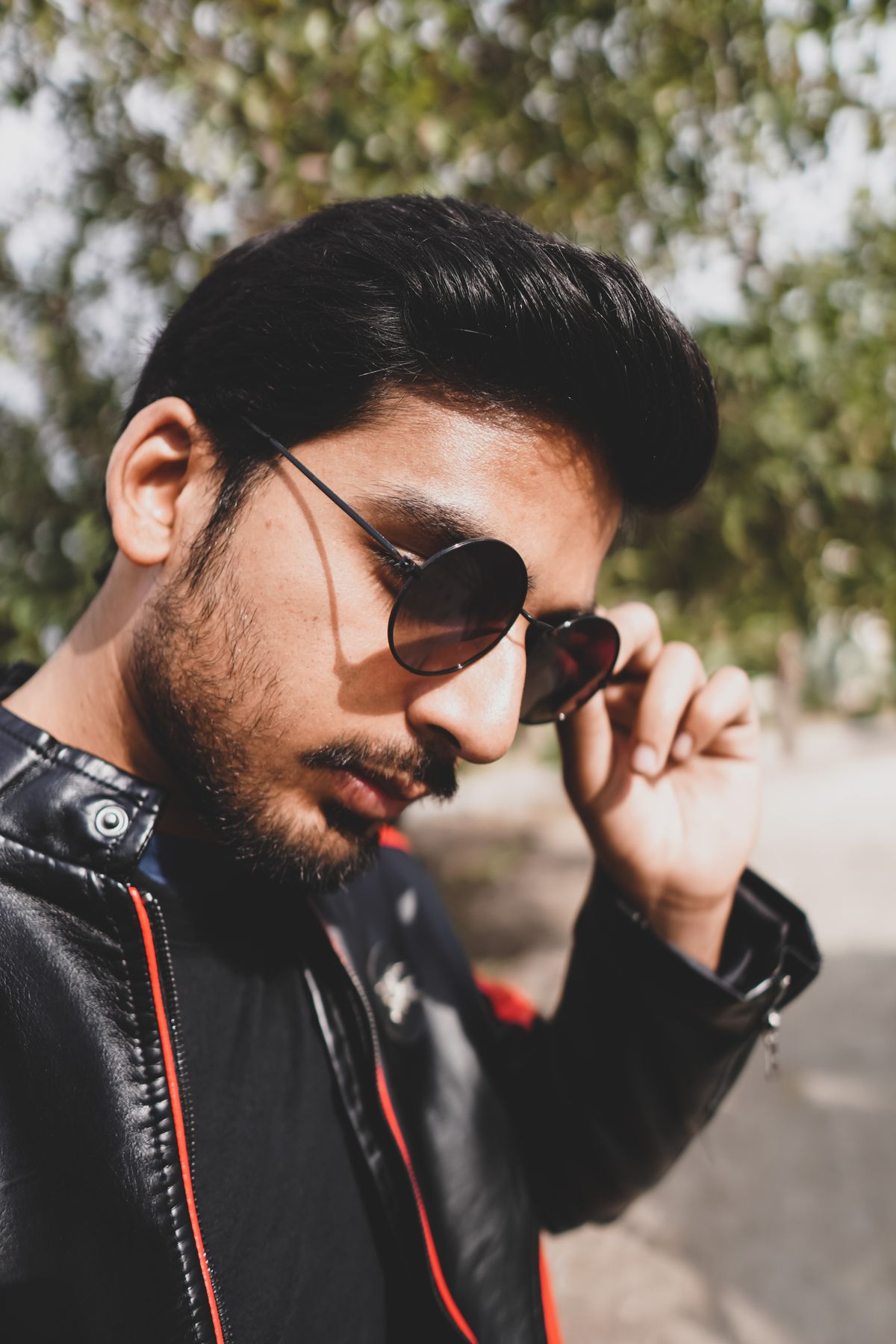 A man adjusting the arms of his sunglasses.